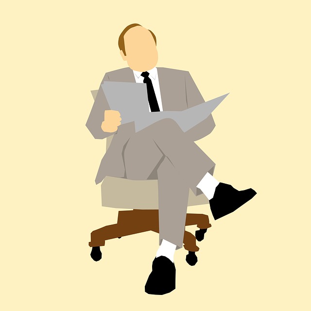 Muž v obleku na kolečkovém křesle držící papíry